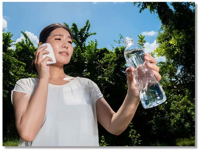 汗をかいて水を飲む女性